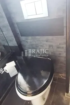 Modernly equipped bathroom with dark tiles and a black toilet bowl. - image 6