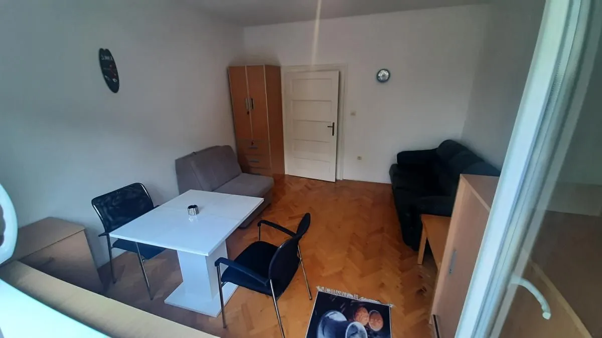 Dnevna soba sa trpezarijskim stolom i garniturom za sedenje.