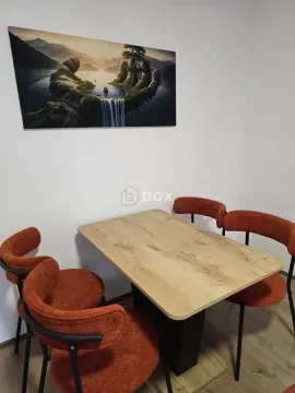 Trpezarijski sto sa narandžastim stolicama i umetničkom slikom na zidu. - image 4