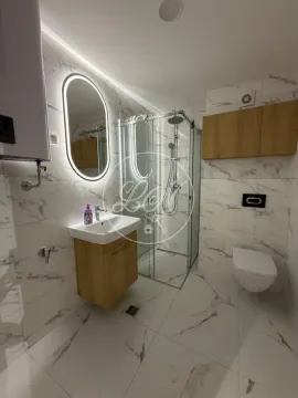 Modern bathroom equipped with a shower enclosure, vanity washbasin, and wall-mounted toilet. - image 12