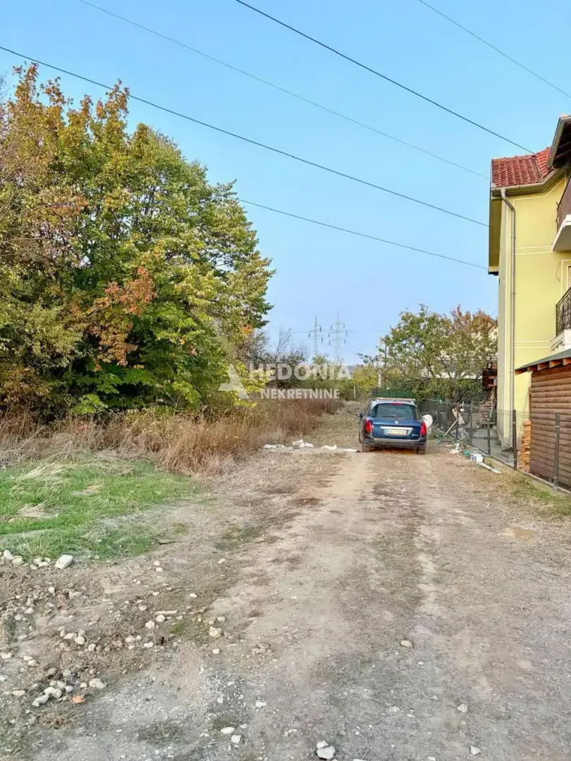 Zemljište sa prilaznim putem i zelenilom pored kuće.