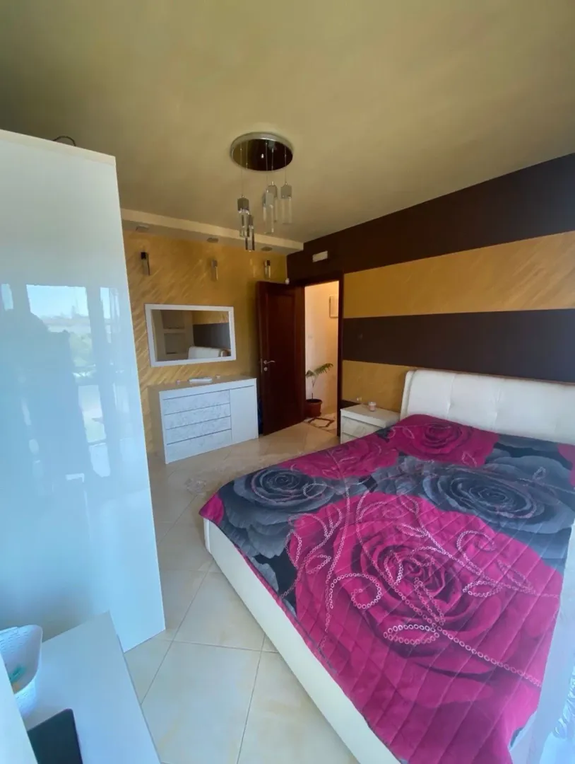 Spavaća soba sa bračnim krevetom, garderoberom i komodom.