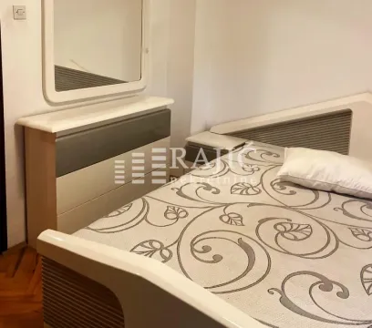 Furnished bedroom with a double bed, dresser, and mirror. - image 5