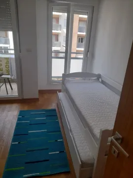 Small bedroom with a pull-out bed and a blue rug. - image 3