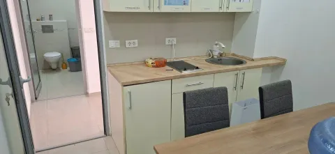Smaller kitchen with countertop, sink and view of the bathroom. - image 2