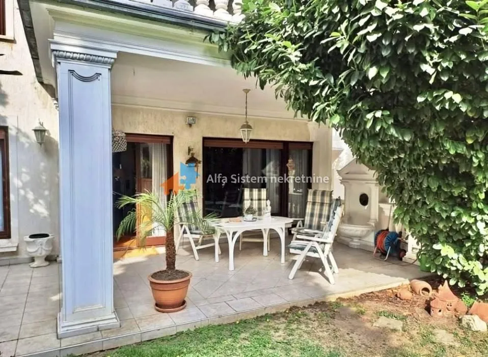 Covered terrace with seating furniture and a view of the yard.