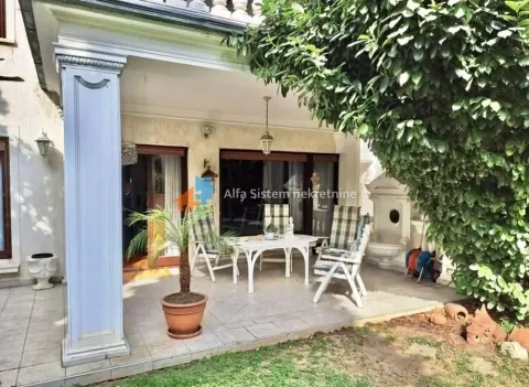 Covered terrace with seating furniture and a view of the yard. - image 26