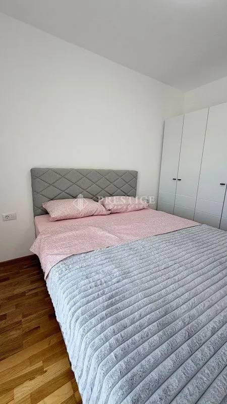 Spavaća soba sa bračnim krevetom i bijelim garderoberom.