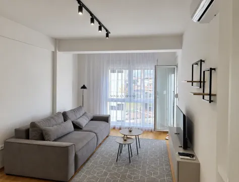 Dnevna soba sa sivom garniturom, stočićima i televizorom. - image 4