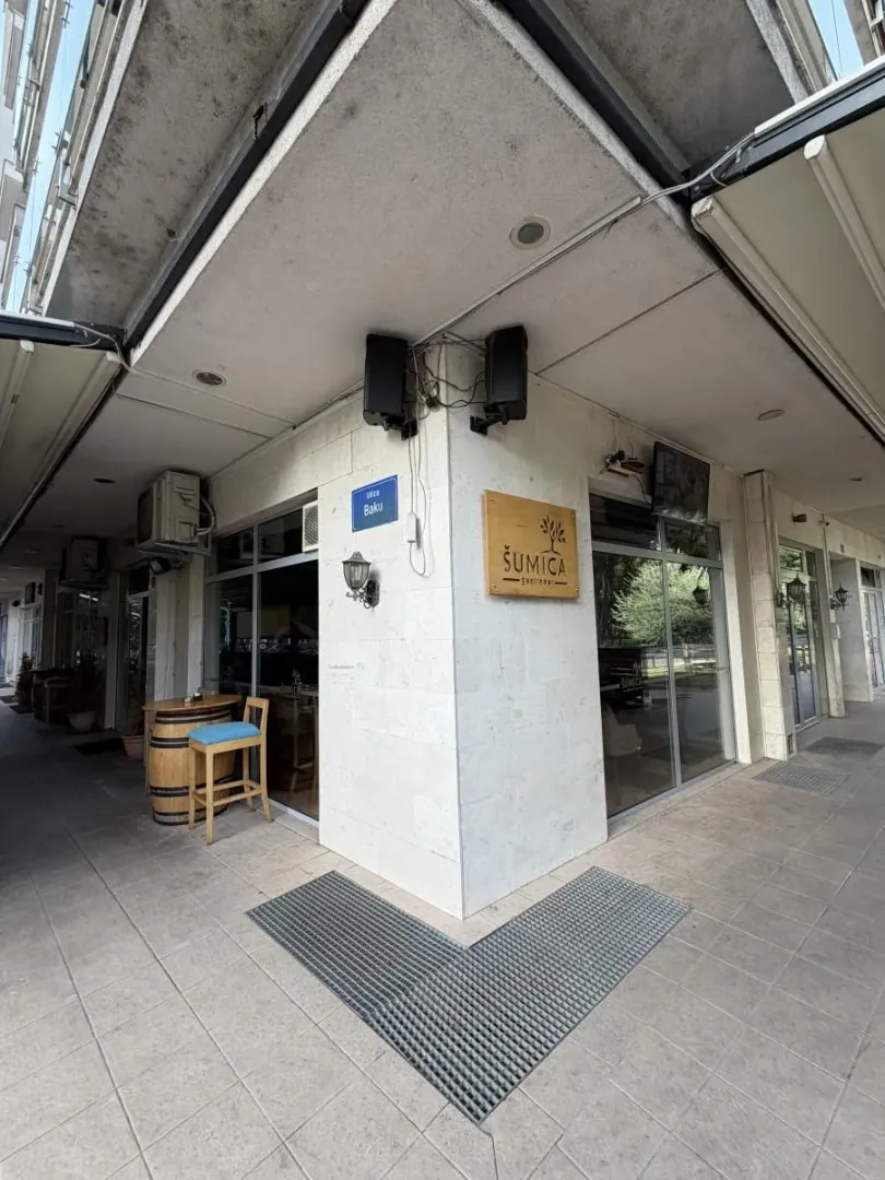 Exterior view of the commercial space with a sign and sidewalk in front.