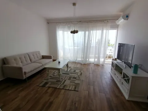 Dnevna soba sa garniturom, stočićem, televizorom i izlazom na terasu. - image 8