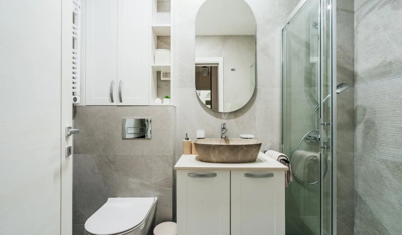 Modern bathroom equipped with a walk-in shower, washbasin, and built-in cabinetry.