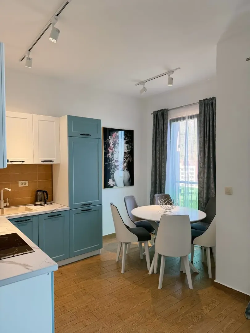 Modern kitchen with dining area and blue cabinets.