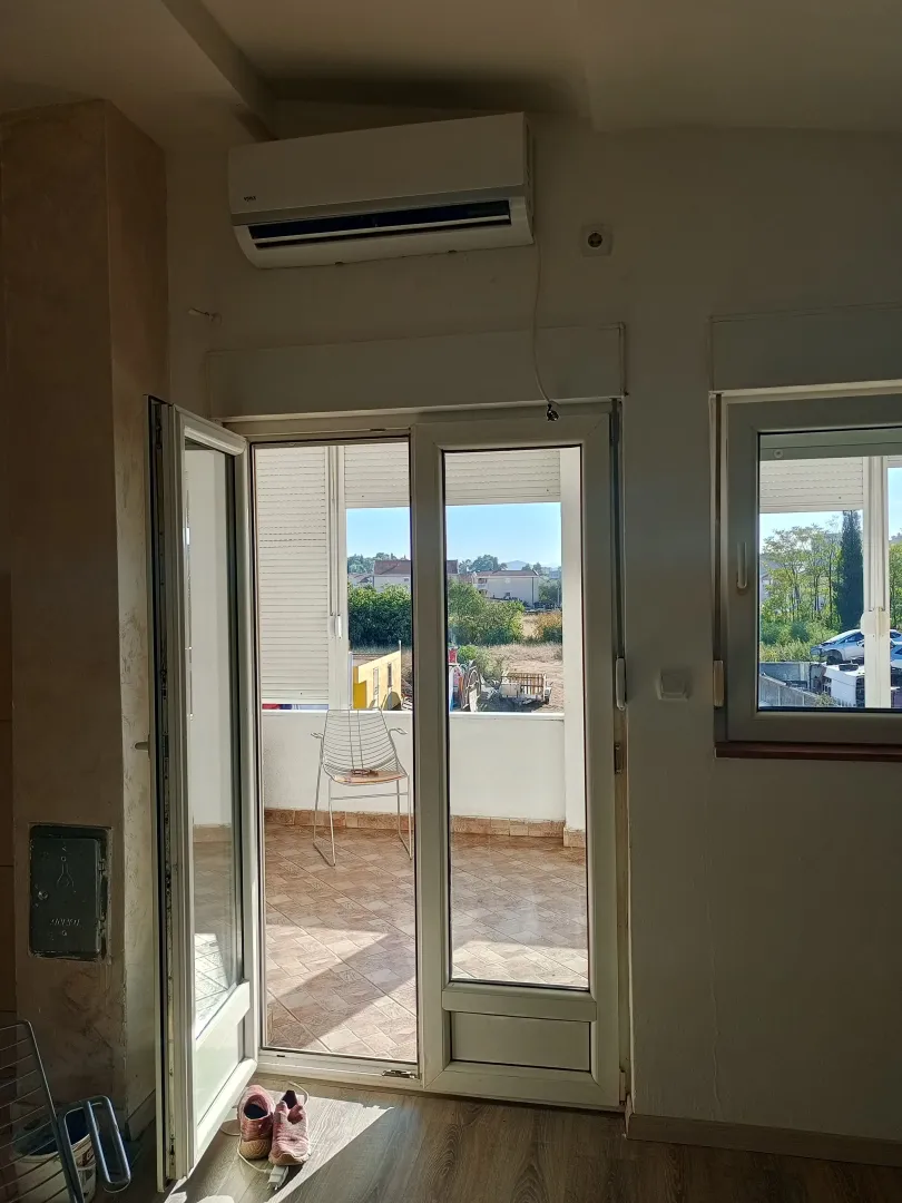 Pogled iz prostorije prema terasi kroz otvorena balkonska vrata.