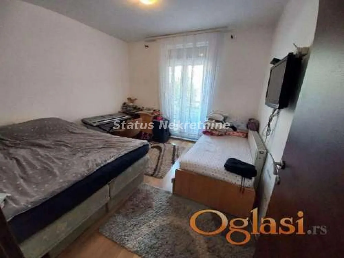 Spavaća soba sa dva kreveta i izlazom na terasu.