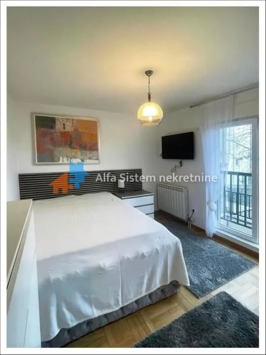 Furnished bedroom with a double bed and balcony access.