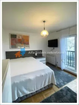 Furnished bedroom with a double bed and balcony access. - image 6