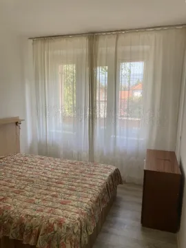 A bedroom with a double bed and a curtained window. - image 5