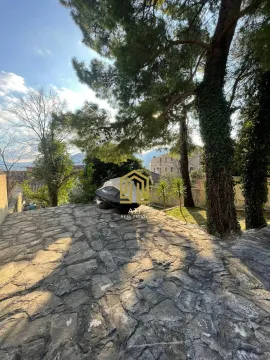 Popločano dvorište sa drvećem i pogledom na okolne objekte. - image 10