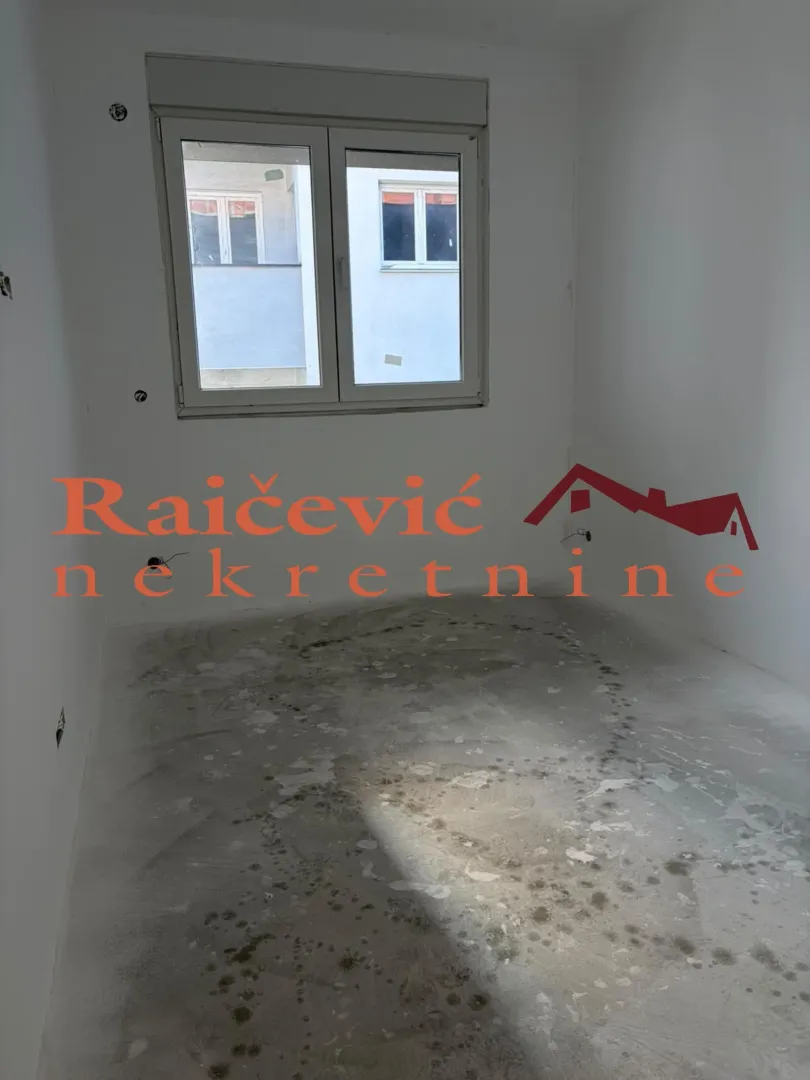 Prazna neuređena prostorija sa prozorom u nekretnini u izgradnji.