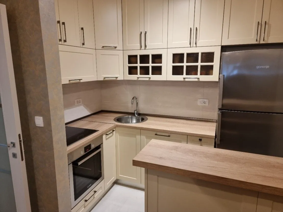 Bright kitchen with a wooden countertop and a built-in oven.