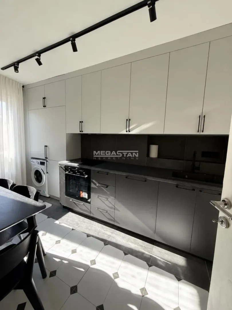 Modern kitchen with built-in appliances and a dining table.