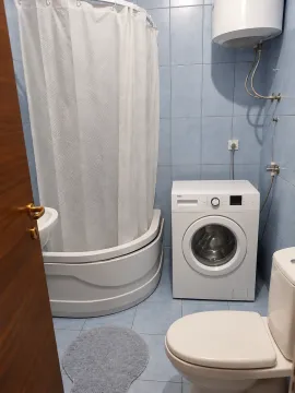 Manje kupatilo obloženo pločicama sa tuš kabinom i veš mašinom. - image 6
