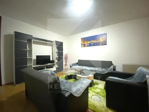 Living room with a sofa set, television, and TV unit. - image 3