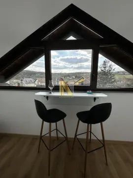 Attic space with a dining table and window view. - image 18