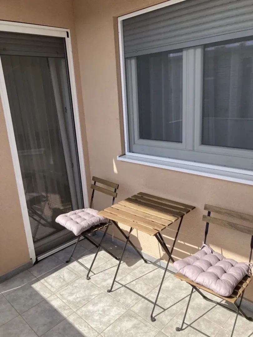 Small terrace with a wooden table and chairs.