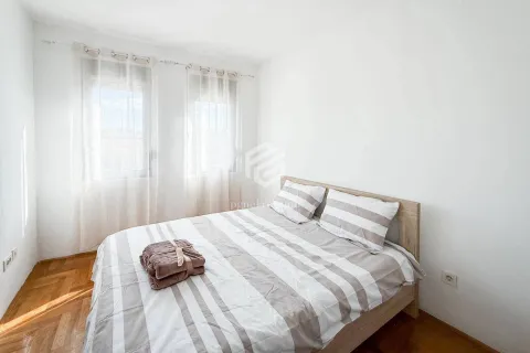 Svijetla spavaća soba sa bračnim krevetom i prozorima prekrivenim zavjesama. - image 3