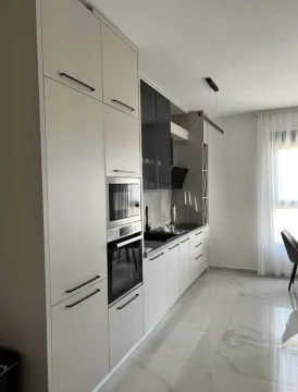 Modern kitchen with built-in appliances and light floor tiles. - image 4