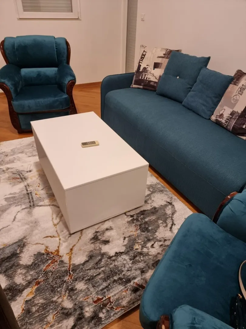 Living room with a blue sofa set and a white table.