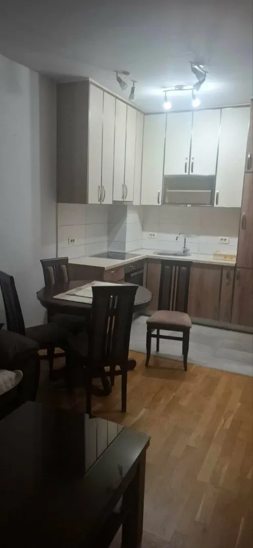 Kuhinja sa trpezarijskim stolom i stolicama.
