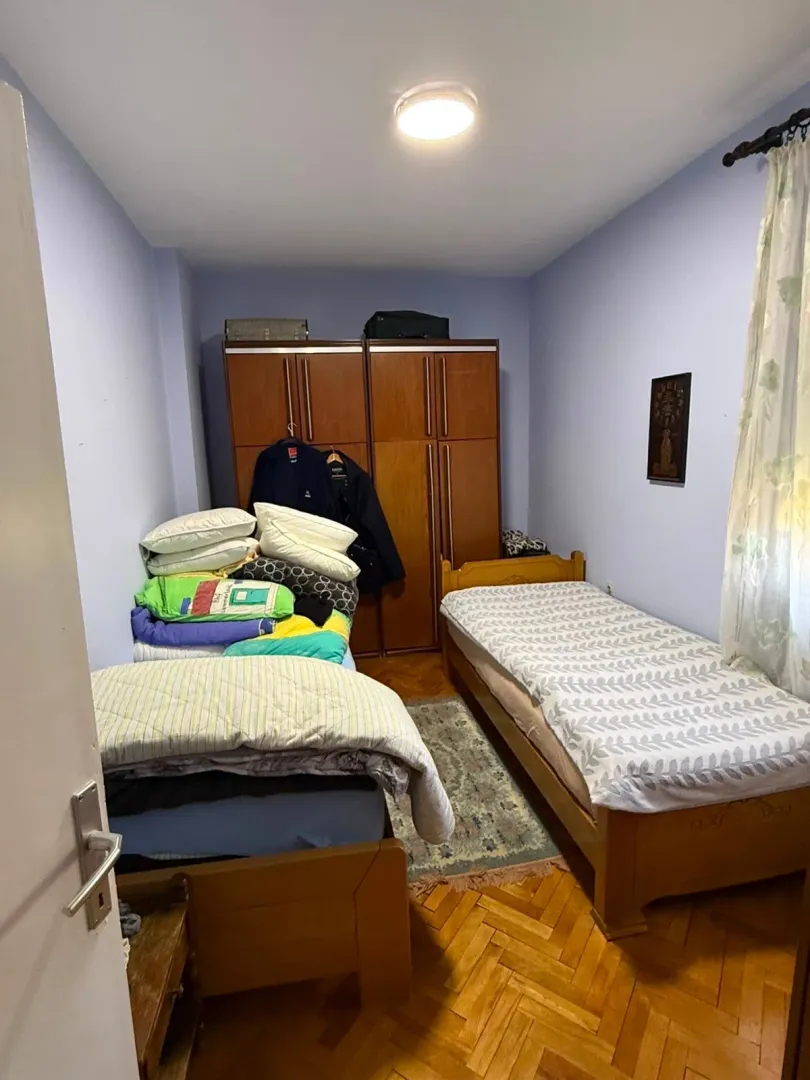 Smaller bedroom with two beds and a wardrobe.