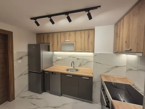 Modern kitchen with wooden elements, built-in appliances and marble-look tiles. - image 6