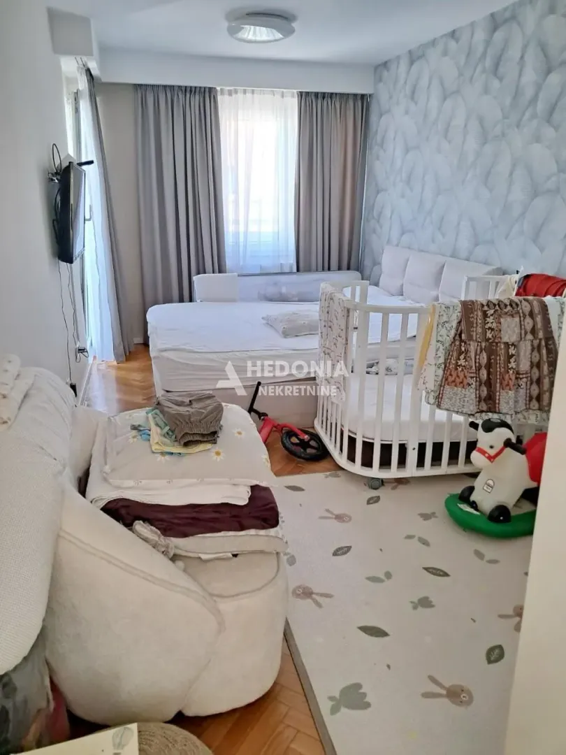 Dečja spavaća soba sa krevetom, krevetcem i igračkama.
