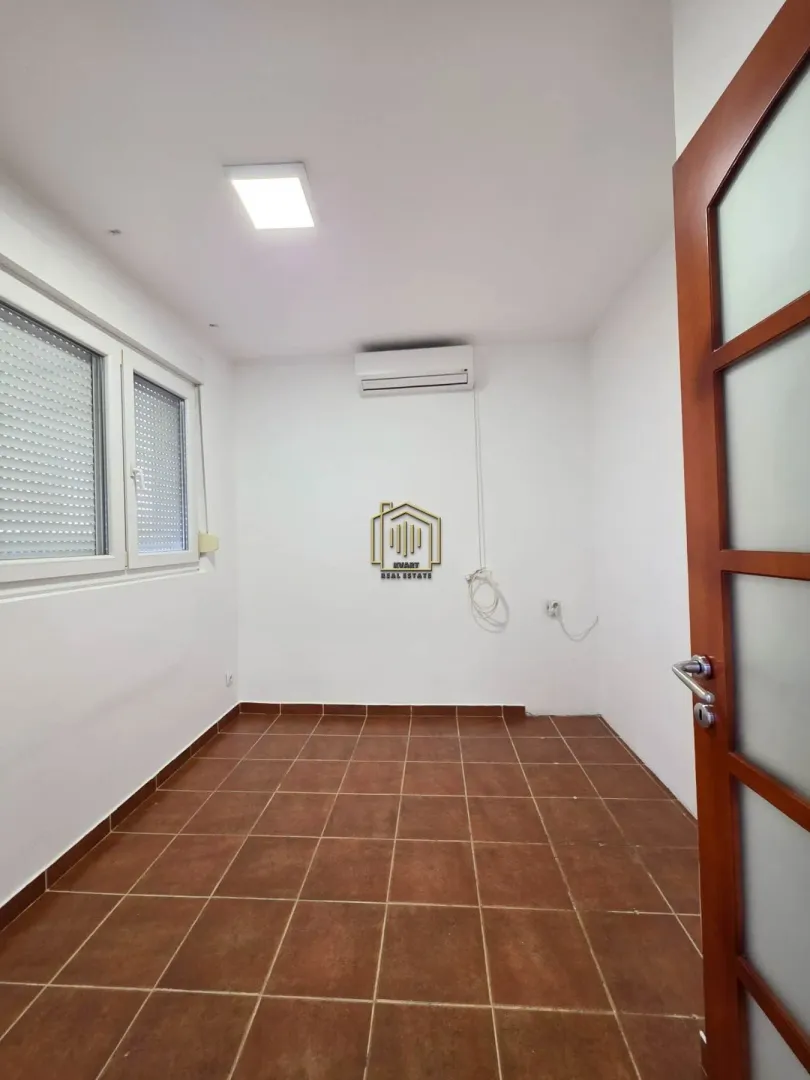 Empty bright room with ceramic floor tiles and an air conditioning unit.