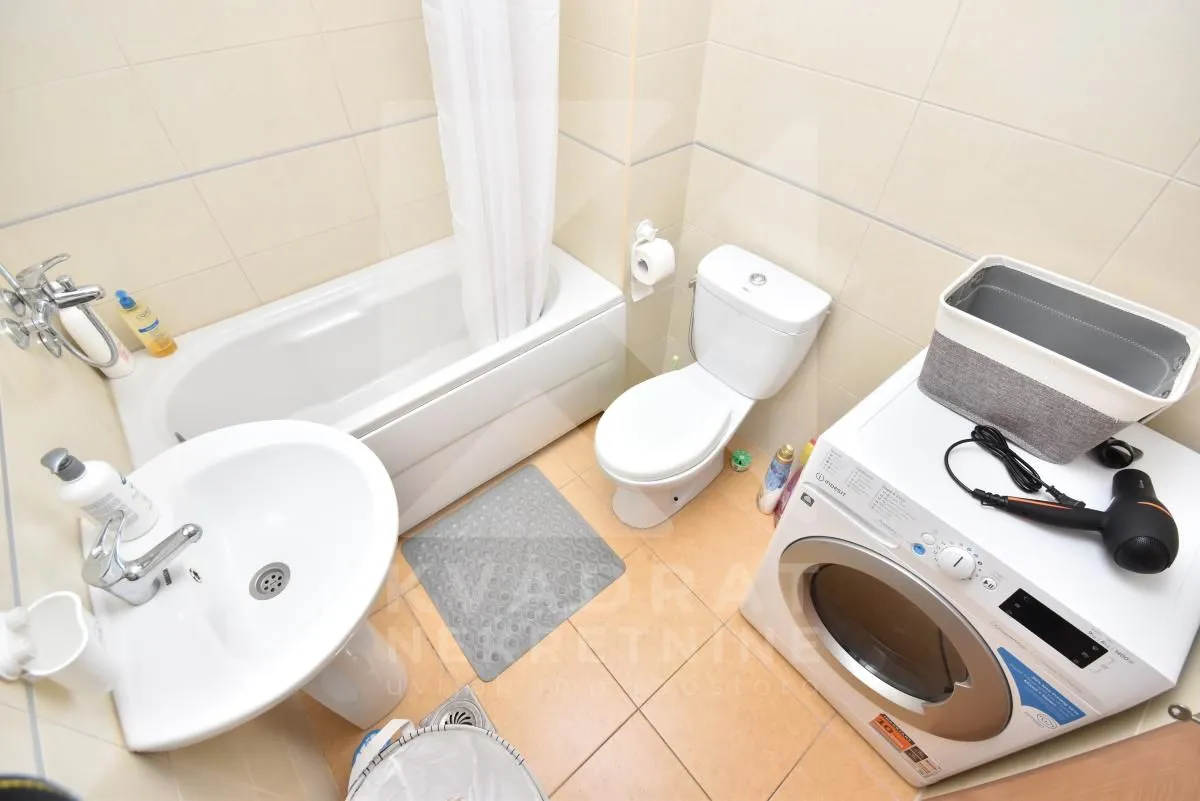 Bathroom equipped with a bathtub, washbasin, toilet, and washing machine.