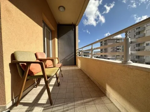 Natkriveni balkon sa stolicama i pogledom na okolne zgrade. - image 18