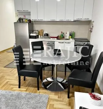 Dining area connected to the kitchen with white cabinetry and a dining table with black chairs. - image 5