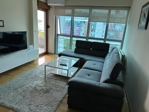 Dnevna soba sa ugaonom garniturom, televizorom i velikim prozorima. - image 16