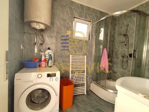 Bathroom with a shower cabin, washing machine, and water heater. - image 8