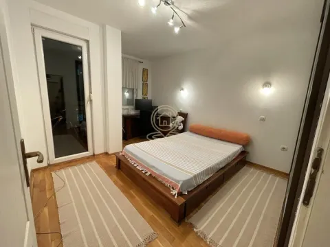Nameštena spavaća soba sa bračnim krevetom, drvenim podom i izlazom na terasu. - image 6