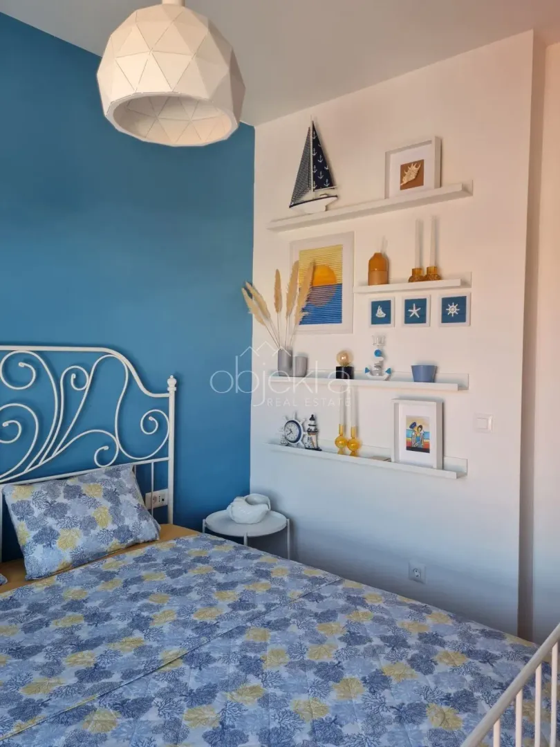 Spavaća soba sa krevetom i detaljima u pomorskom stilu.