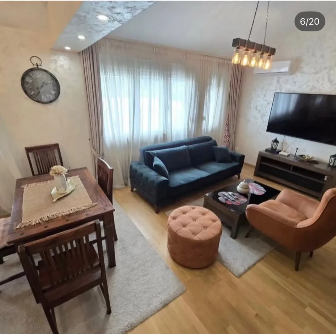 Spacious living room with a dining table, sofa set, and television.