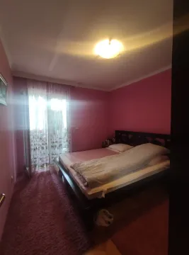 Simple bedroom with pink walls, a double bed, and balcony doors. - image 5