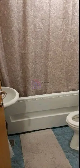 Bathroom with a bathtub, washbasin, and toilet bowl.