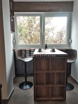 Small kitchen with a breakfast bar and bar stools by the window. - image 3