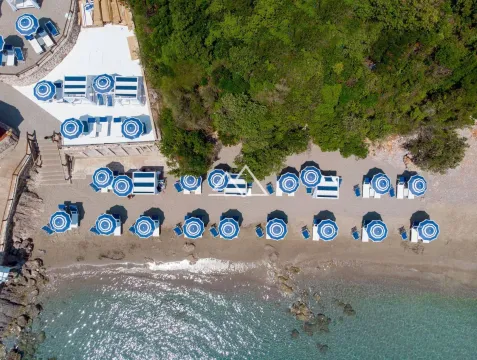 Pogled iz vazduha na uređenu plažu sa suncobranima i ležaljkama pored mora. - image 36
